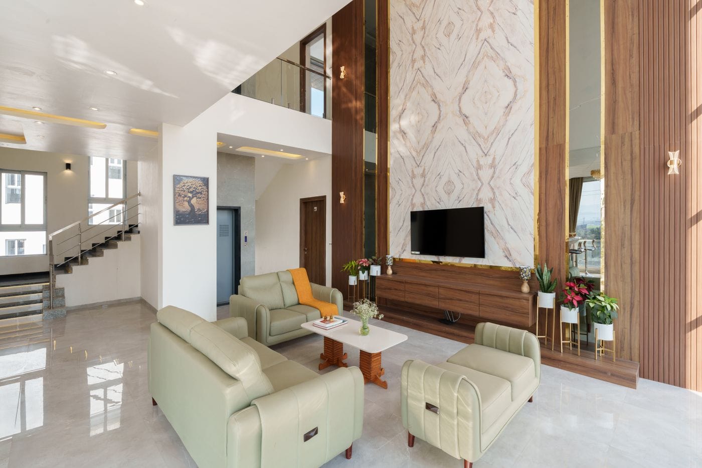 Double height living room with a feature wall, staircase and soft curtains