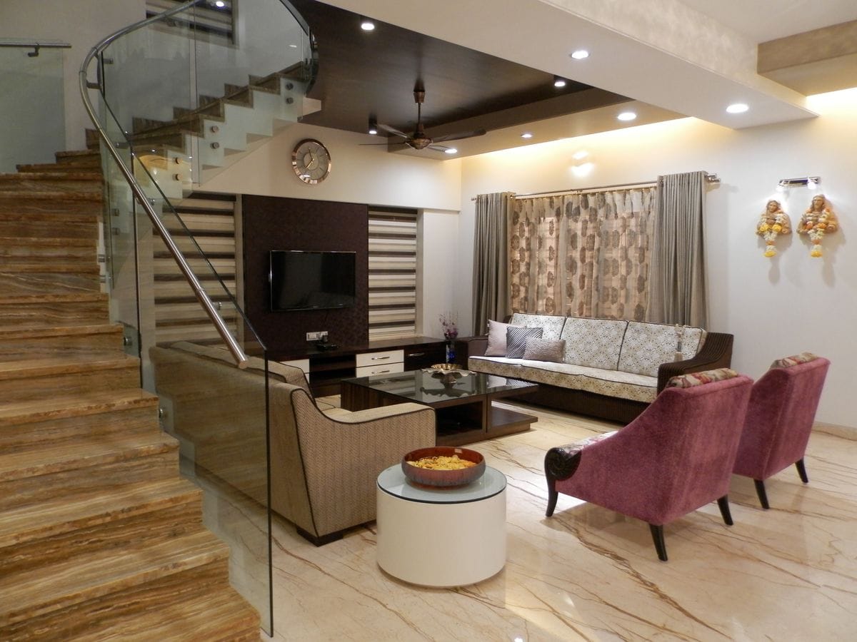 Living room beside a staircase with a glass balustrade